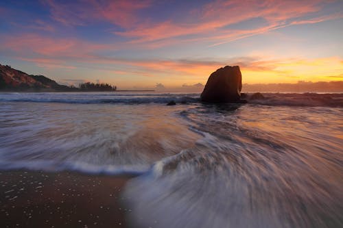 Gratis Fotografi Selang Waktu Gelombang Bergegas Ke Pantai Selama Golden Hour Foto Stok