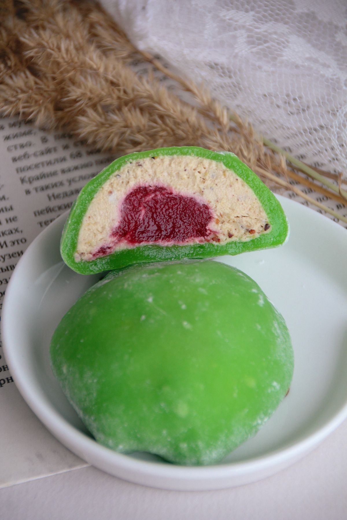 Klepon hijau bulat kecil dari tepung ketan berisi gula merah dengan taburan kelapa parut yang khas