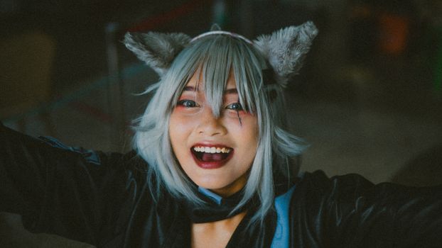A joyful woman in cosplay costume with animal ears, expressing happiness.
