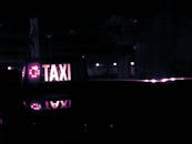 夜间出租车的标志在忧郁的紫色灯光下反射着光芒