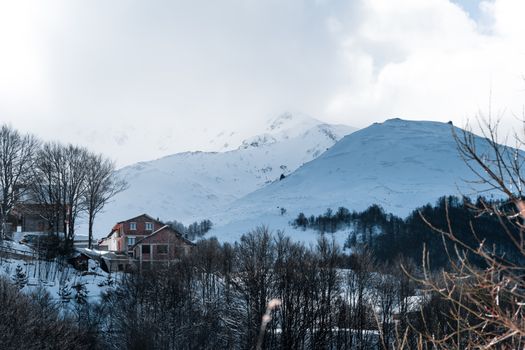 Charming winter scene of snow-covered houses and mountains in Prizren, perfect for travel enthusiasts.