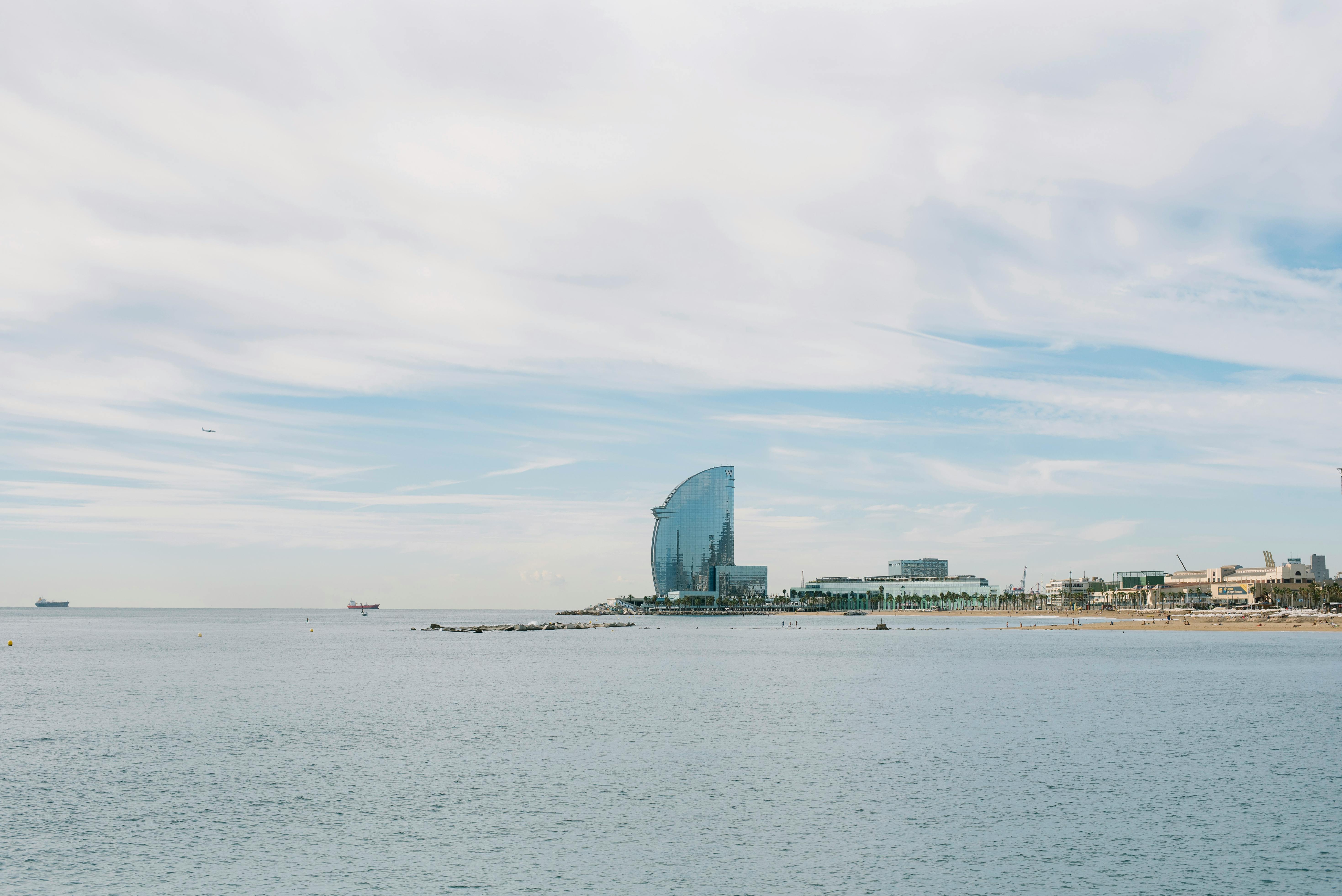 clouds over sea shore with w barcelona behind