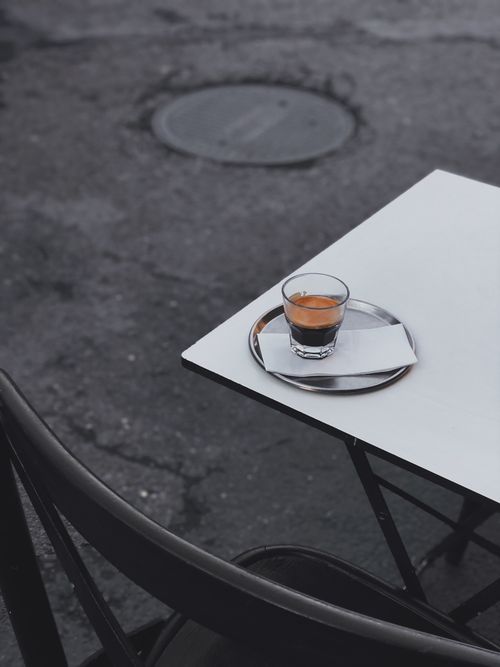 Free A minimalist shot of an espresso on a street-side cafe table, perfect for coffee lovers. Stock Photo