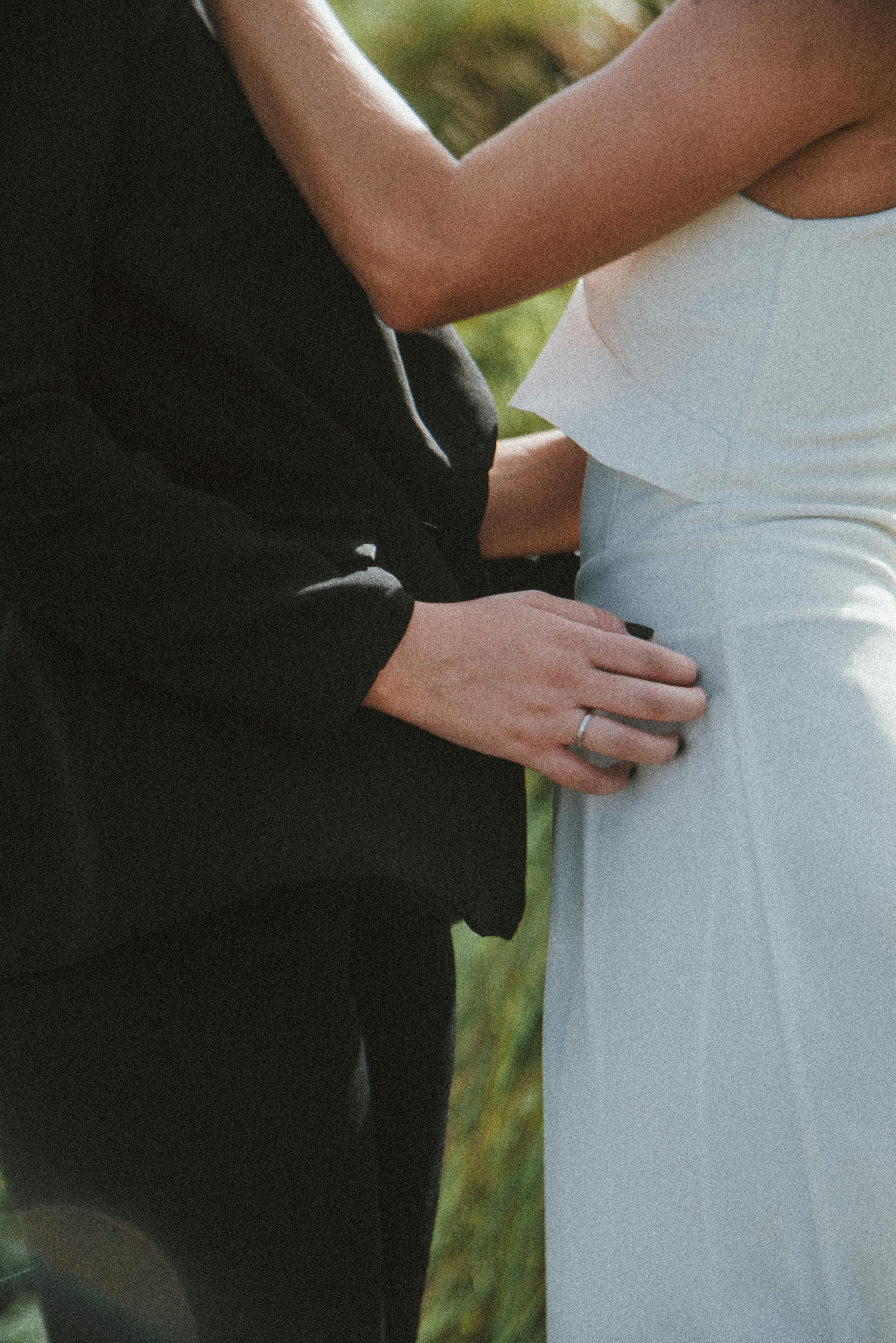 close up of newlyweds standing outside and embracing