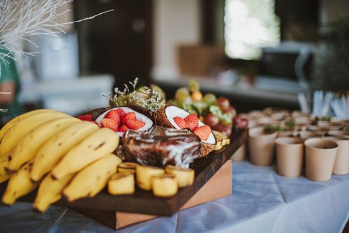 Free Vibrant fruit platter with bananas, strawberries, and coconuts at a buffet with cups, perfect for event catering. Stock Photo