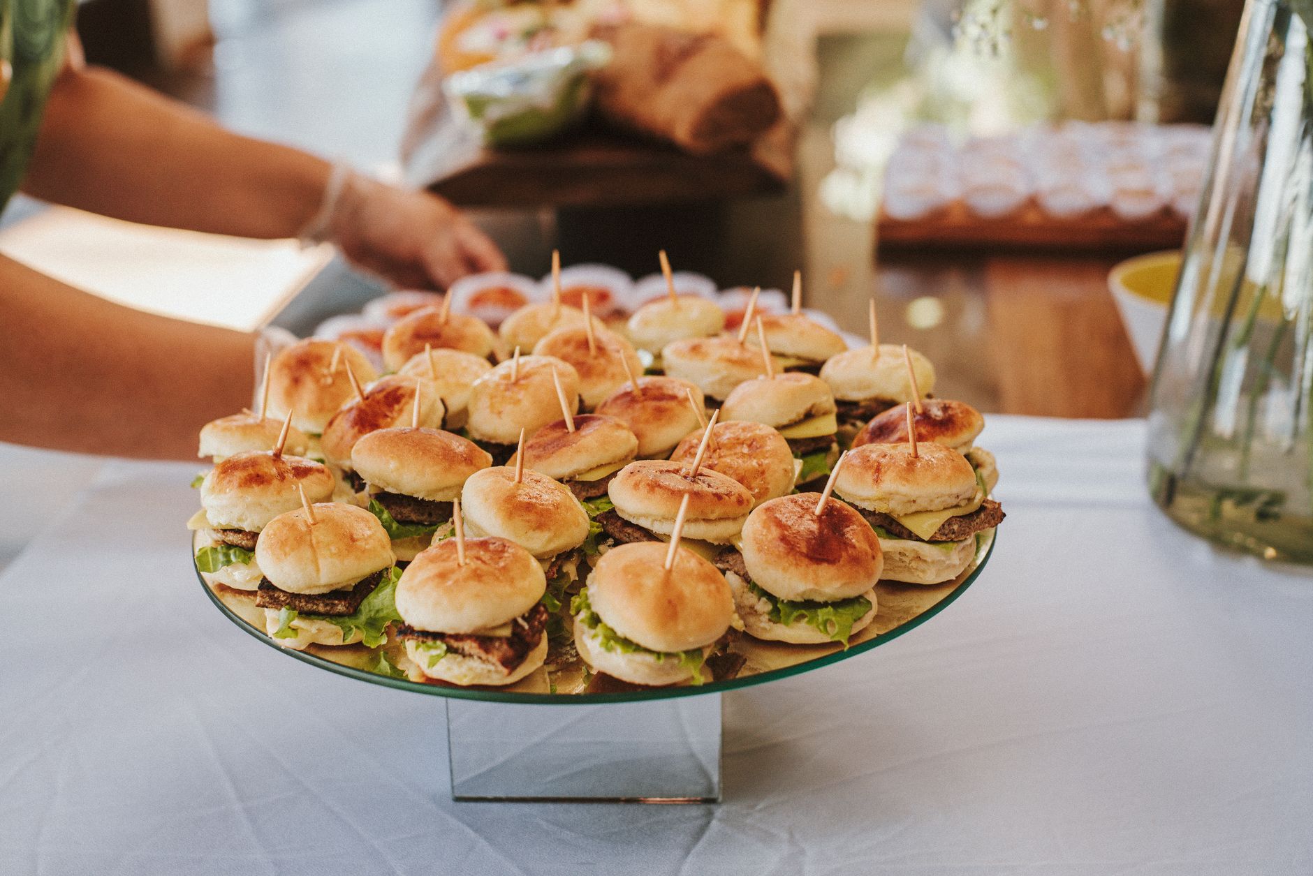 A close-up view of mini burgers on skewers at a buffet table, perfect for events and gatherings.