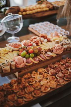 A beautifully arranged charcuterie board featuring cheese, meats, fruits, and sushi rolls perfect for events.