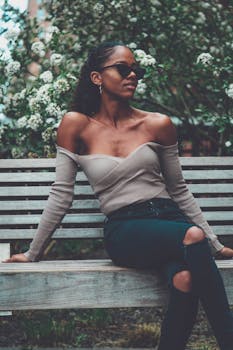 一位穿着休闲服装的时尚女性自信地坐在户外长凳上