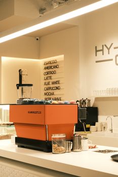 A stylish café interior featuring a vibrant espresso machine and minimalist décor.