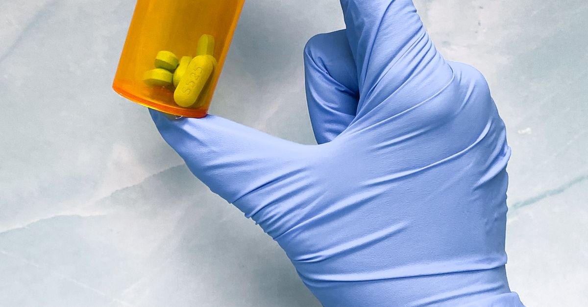 A vial with pills in a hand