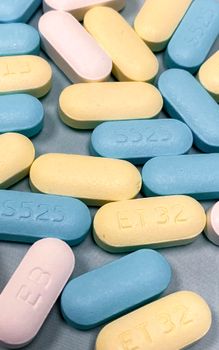 Close-up of assorted colorful medicine tablets scattered on a surface.