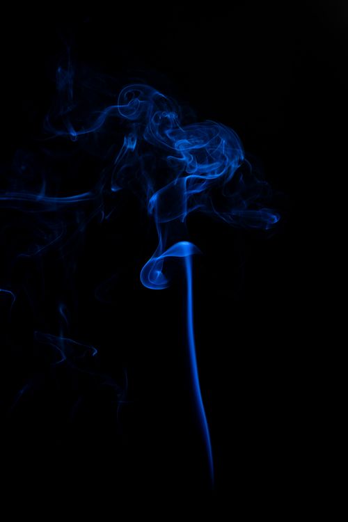 Free Abstract blue smoke swirling gracefully against a dark backdrop, creating a mysterious, artistic effect. Stock Photo