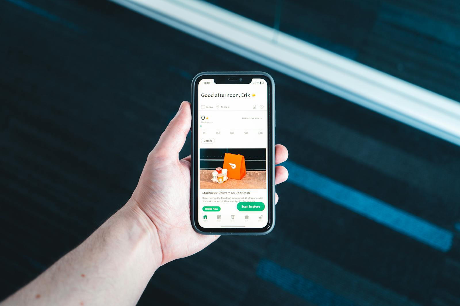 Mano che tiene uno smartphone con app di consegna e schermata ordine