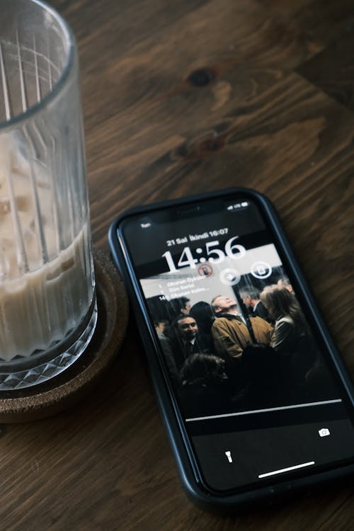 Smartphone Next to a Glass of Unfinished Iced Coffee