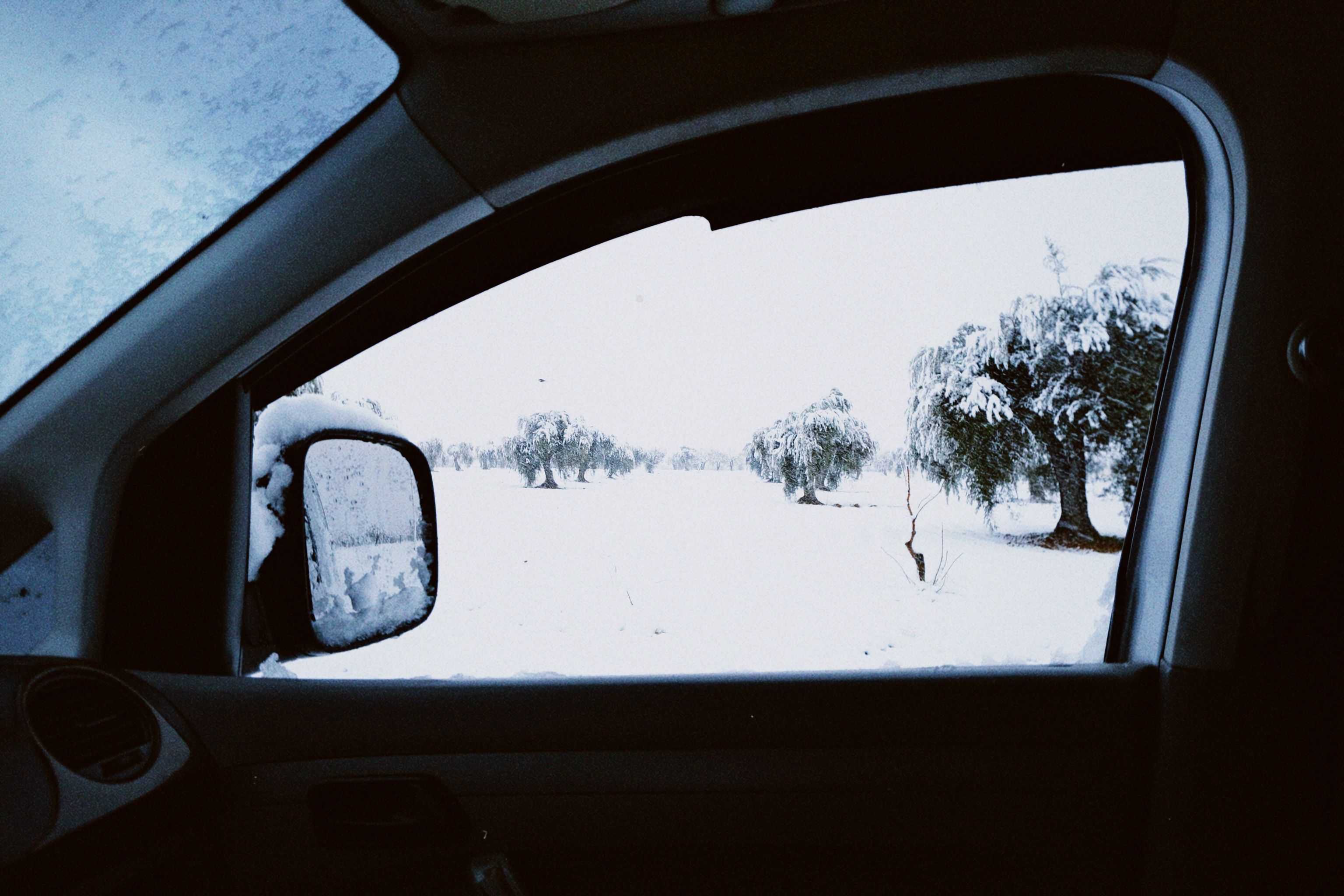 Verschneite Winterlandschaft durch das Seitenfenster eines Autos, ruhig und still