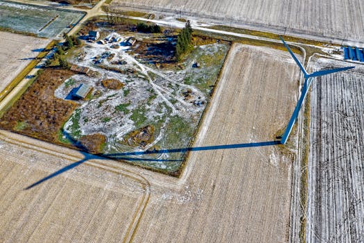 在明尼苏达州寒冷的田野上，风力涡轮机的鸟瞰图投下了阴影