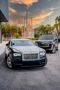 Two luxury cars parked on a city street during sunset, showcasing elegant design.