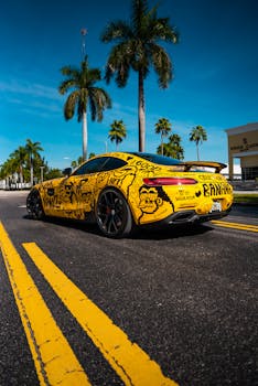 Eye-catching Mercedes AMG with unique graffiti design on sunlit city street.