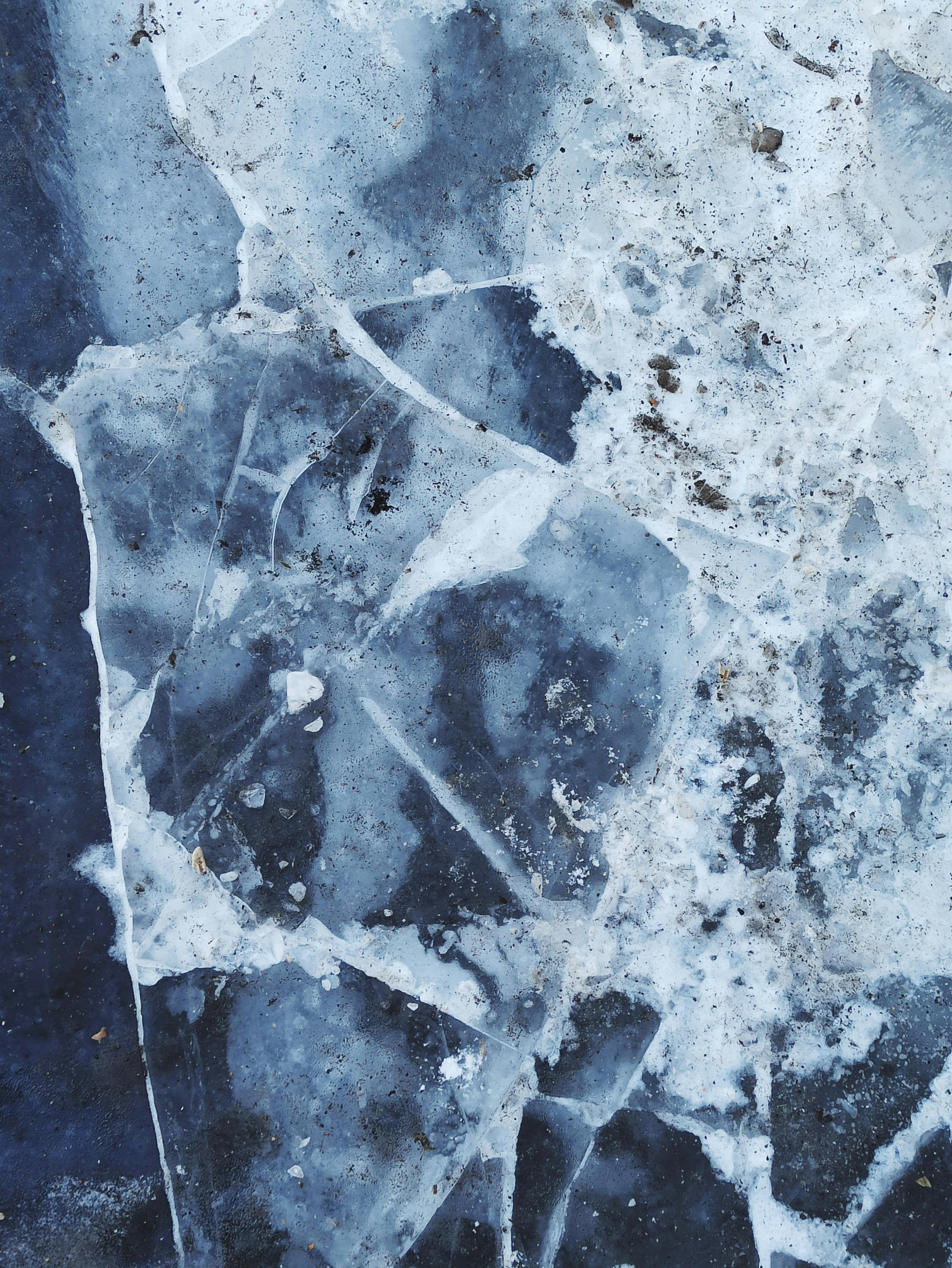 Detailed close-up of a cracked frozen ice surface, capturing winter's frosty patterns.