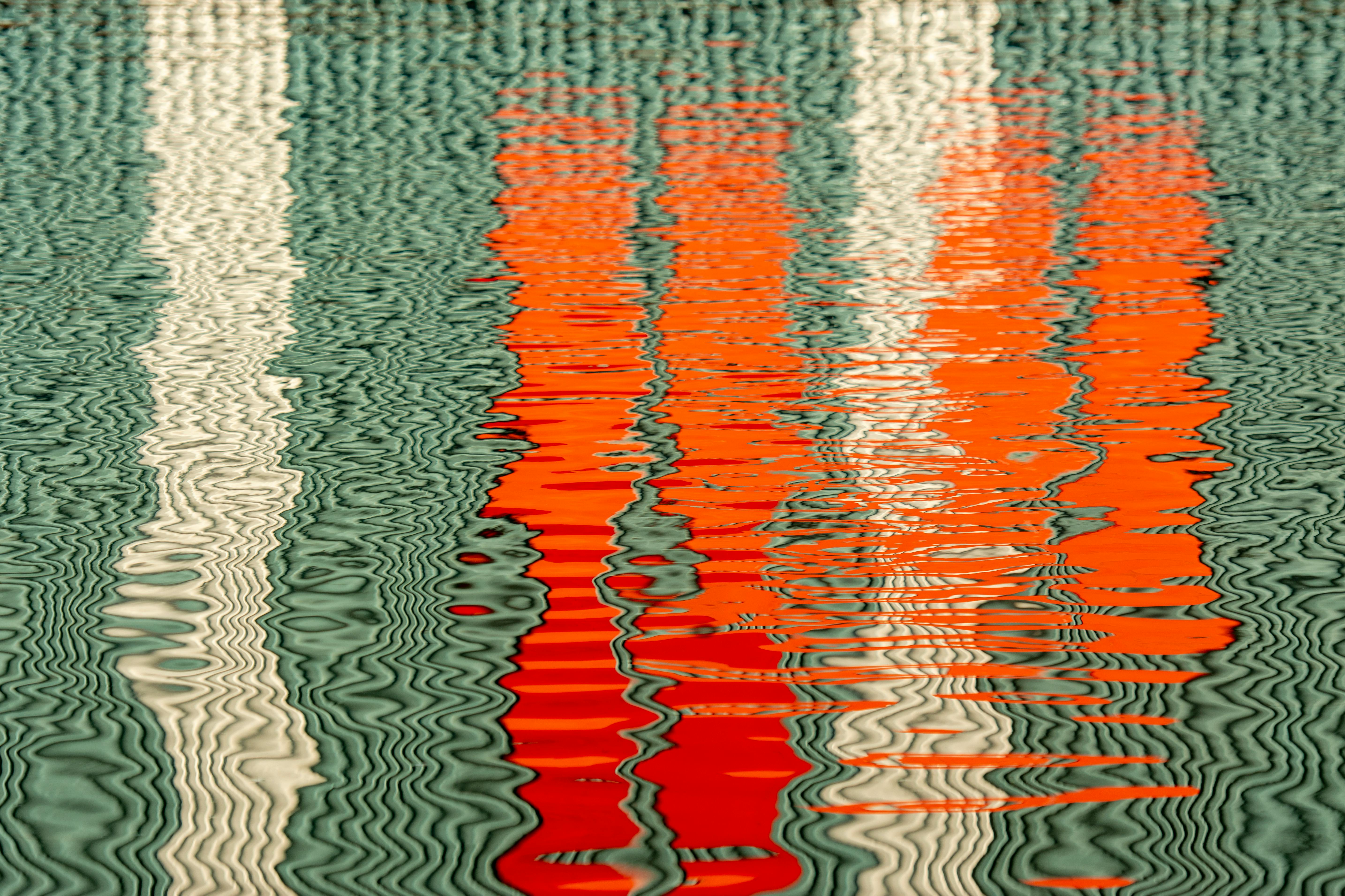 Vivid abstract reflection of colorful patterns on water surface with ripples.