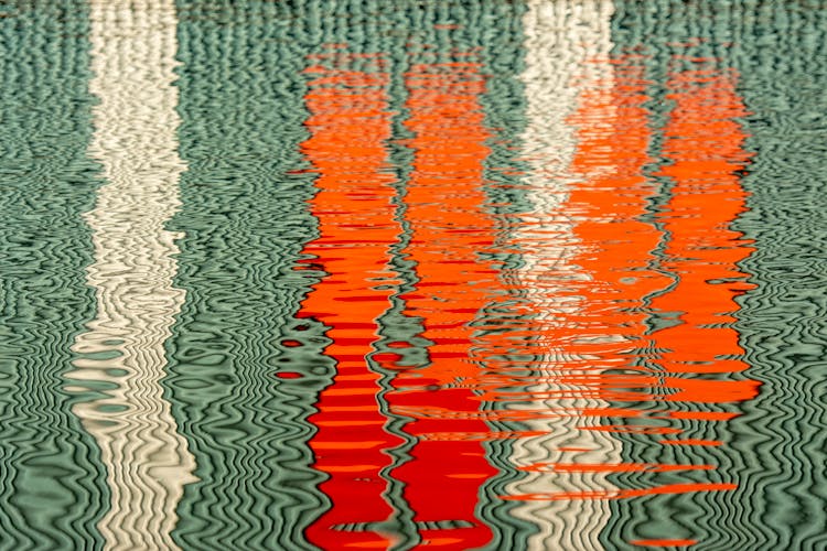 White And Orange Lines Reflecting In The Water Surface