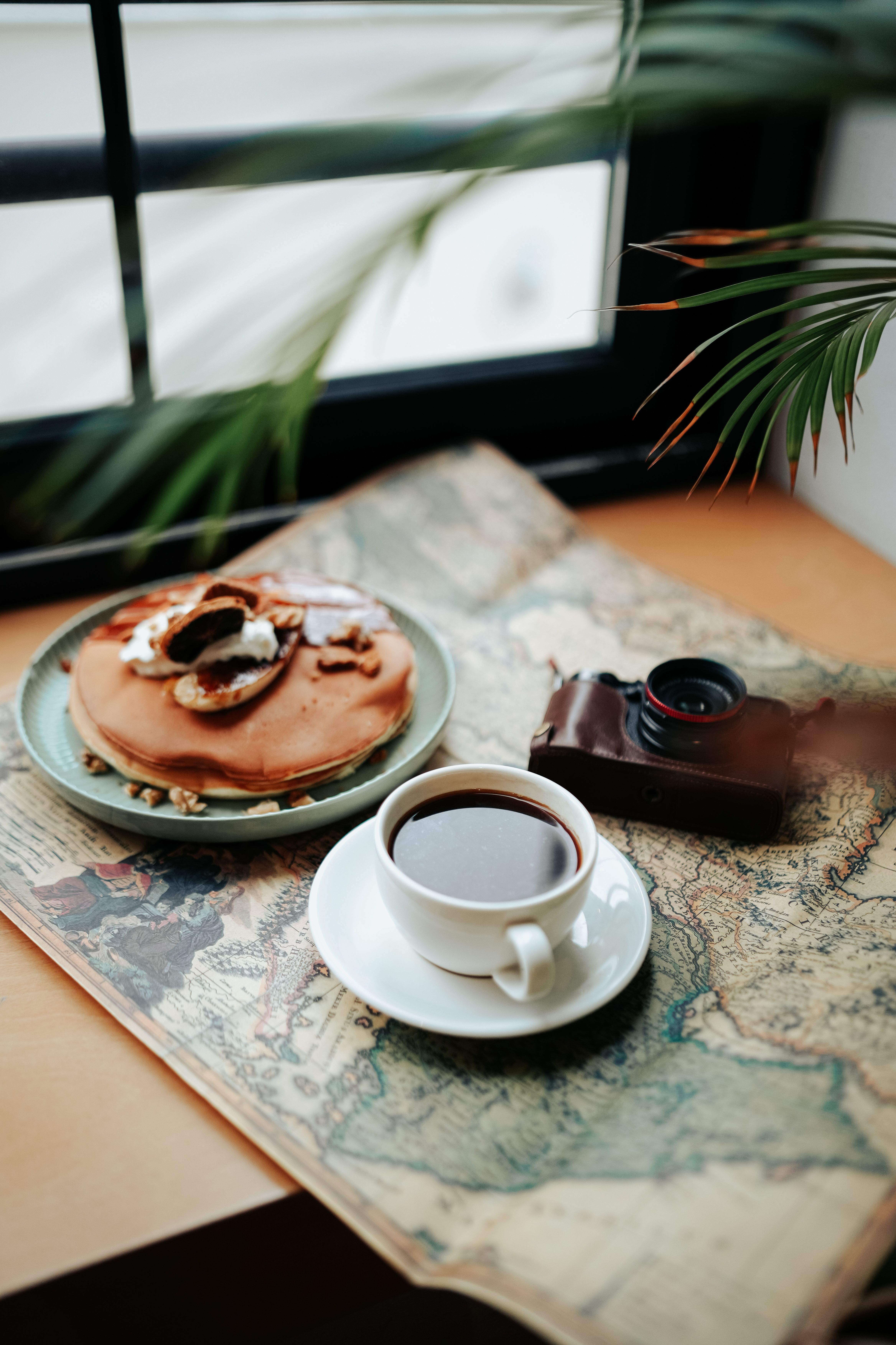 Fotomural Un ambiente cálido de desayuno que presenta café y panqueques sobre un fondo de mapa vintage.