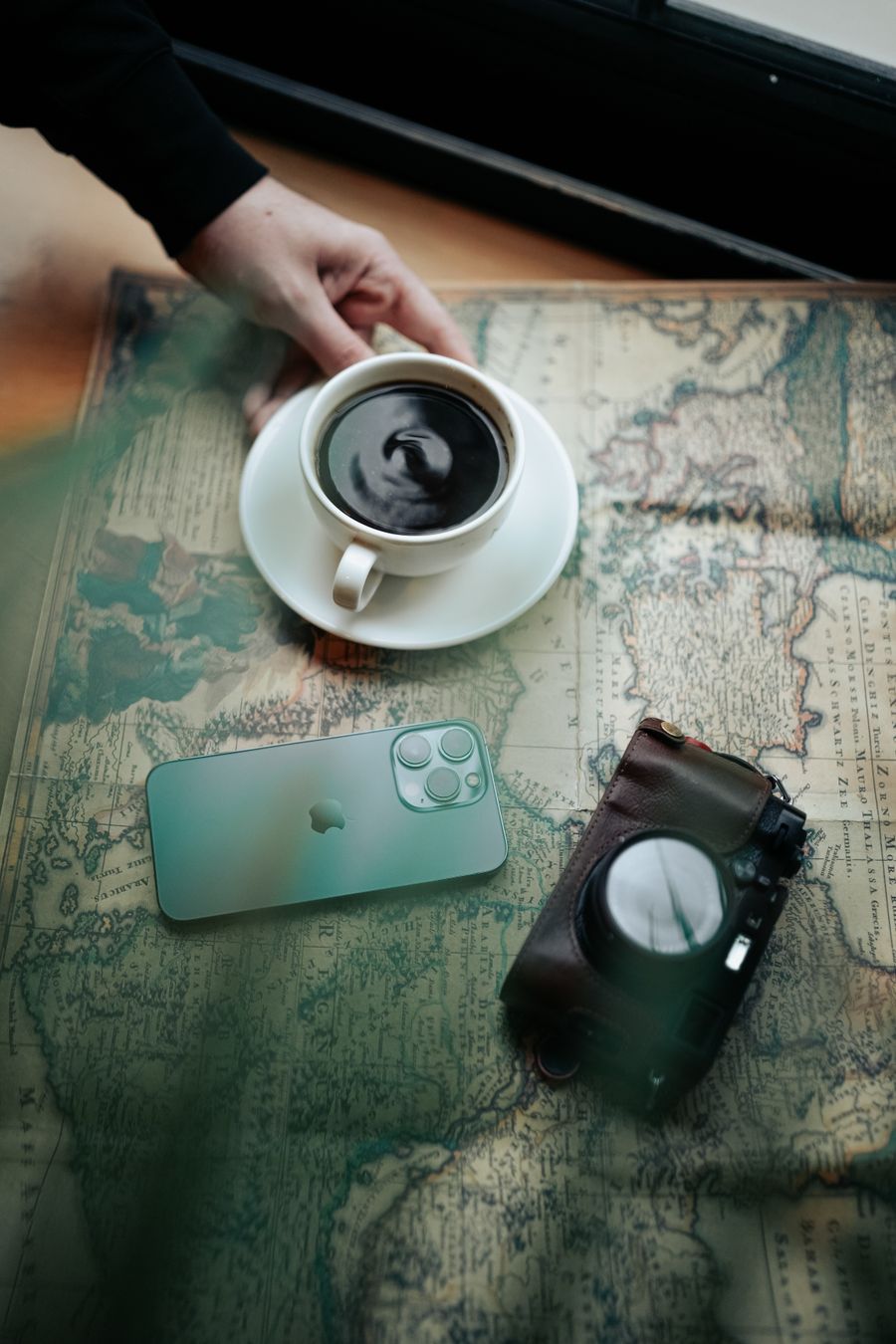 Koffie, camera en smartphone op een reiskaart