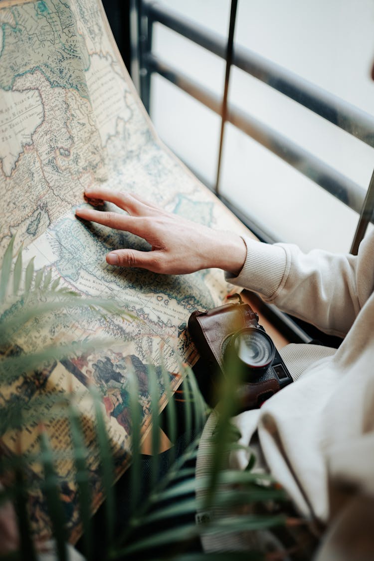 Close-up Of Person Looking At Retro Map