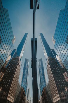 Striking low-angle view of skyscrapers reflecting in glass, showcasing urban architecture.