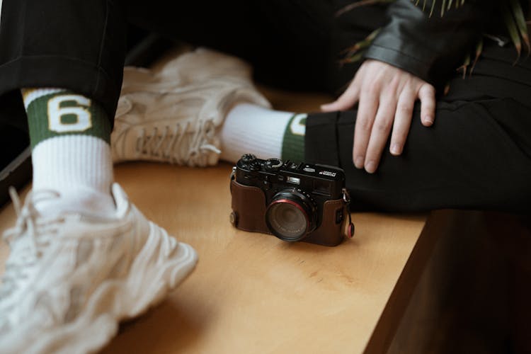 Person In Sneakers Sitting Near Camera