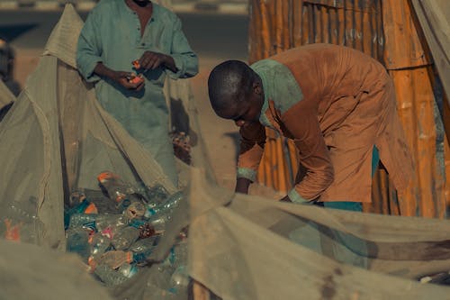 People Putting Plastic Bottles into Bags 