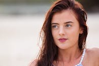 一位头发湿漉漉的年轻女子，若有所思地凝视着户外，这是她的特写肖像