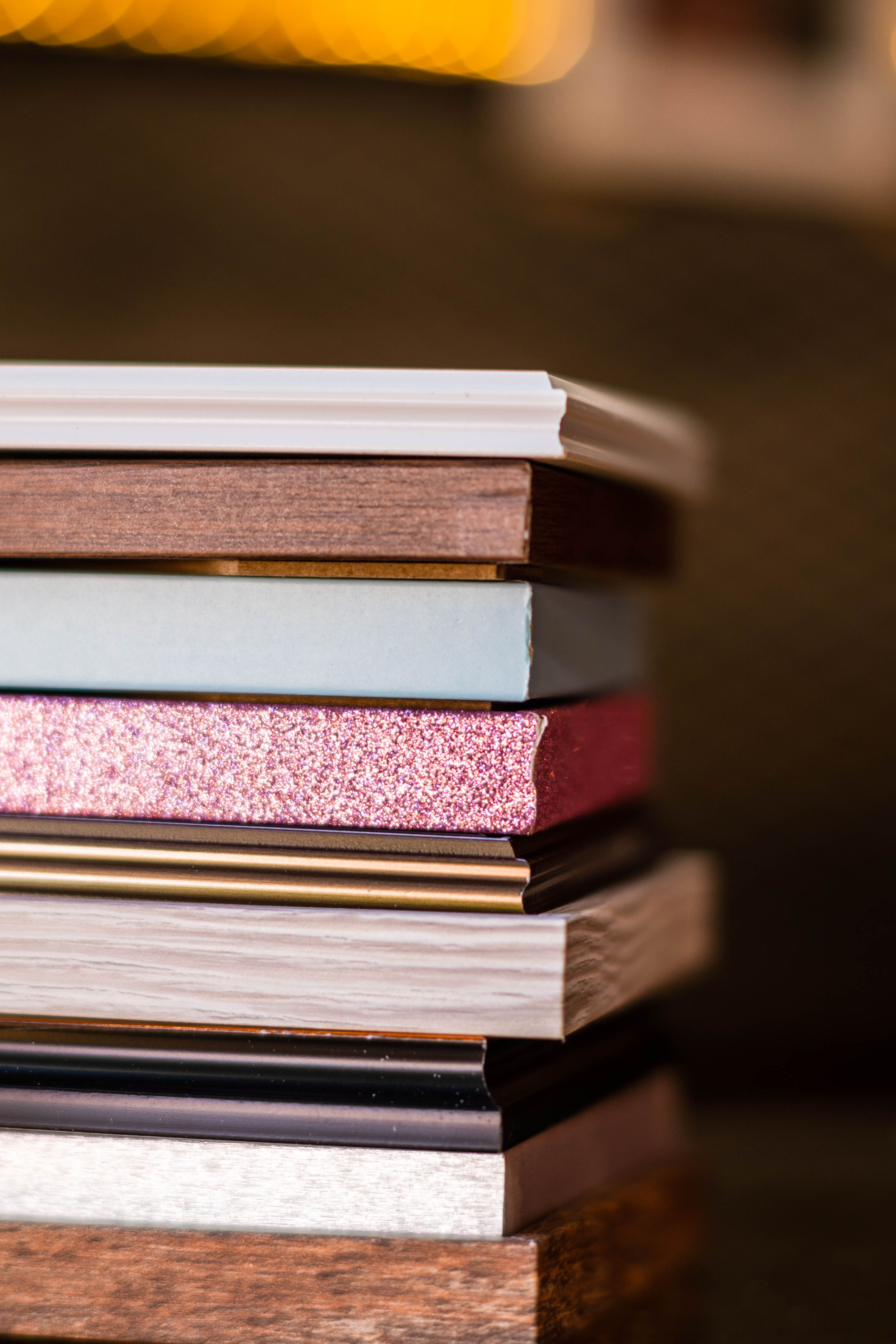 Close-up of a diverse stack of books showcasing various textures and colors, highlighting creative design.