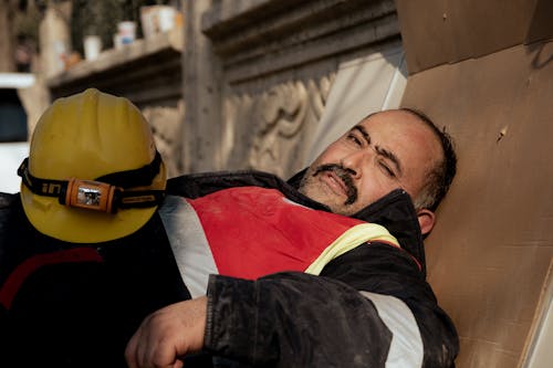 A Construction Worker Lying with a Helmet on His Stomach 