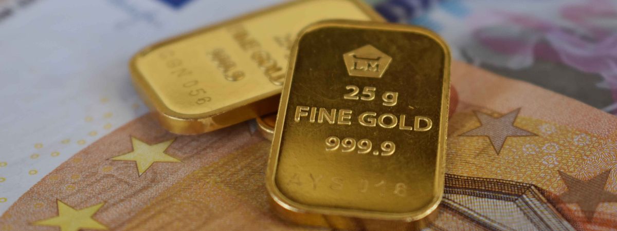 Lingotes de oro sobre billetes de euro