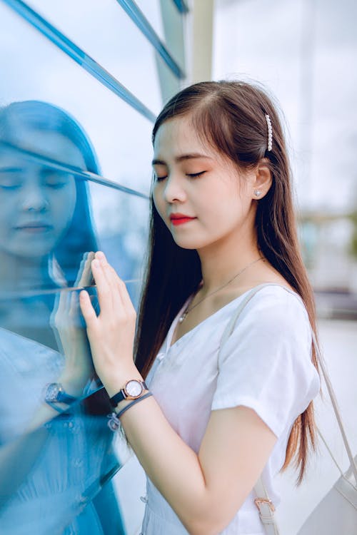 Young Woman Touching the Window with her Eyes Closed