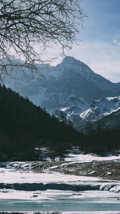 Free Breathtaking view of snow-covered mountains with a frozen lake in winter scenery. Stock Photo