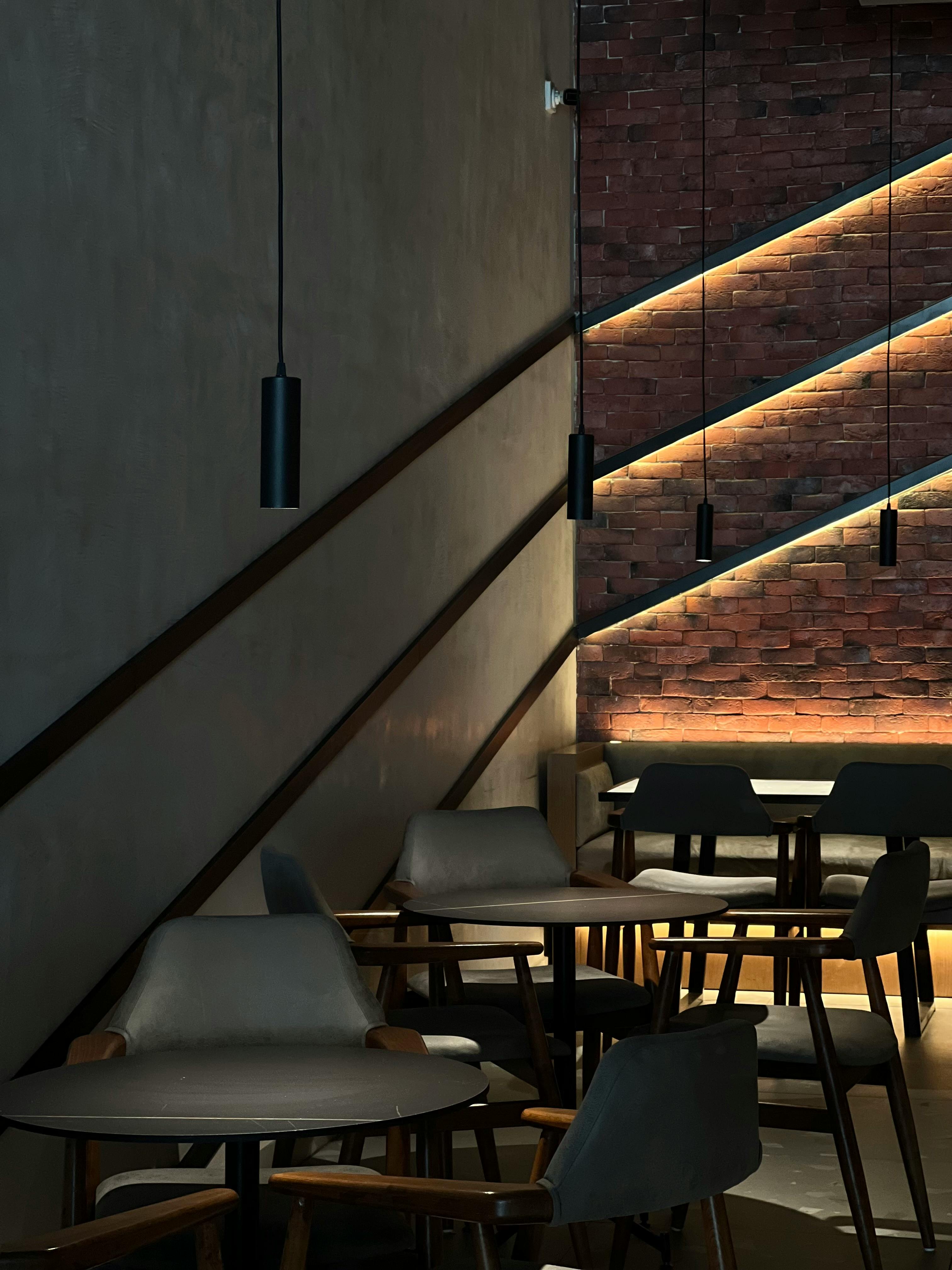 Dimly lit modern cafe with geometric lighting and minimalist furnishings.
