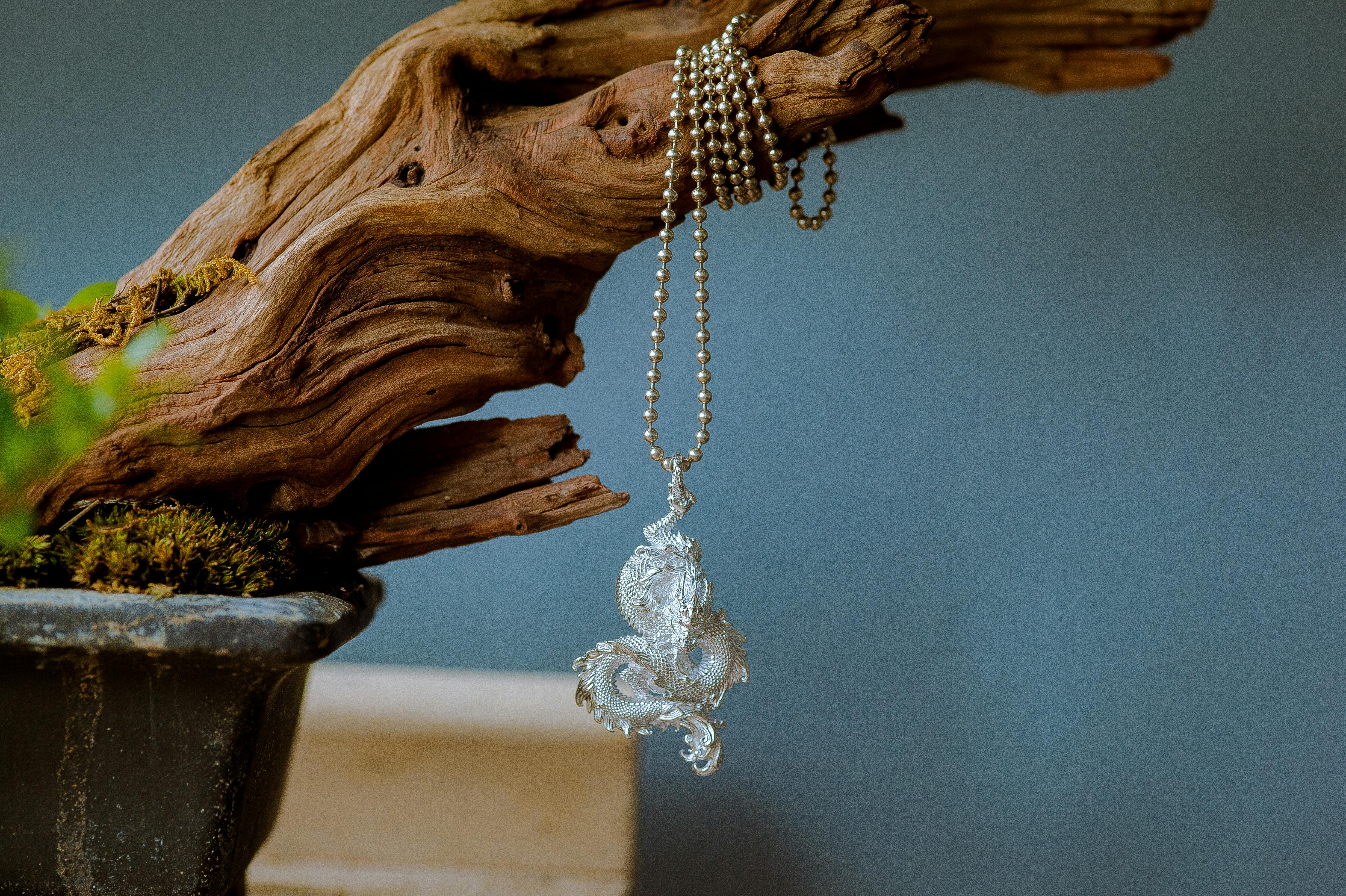 vintage dragon on a chain hanging from a branch