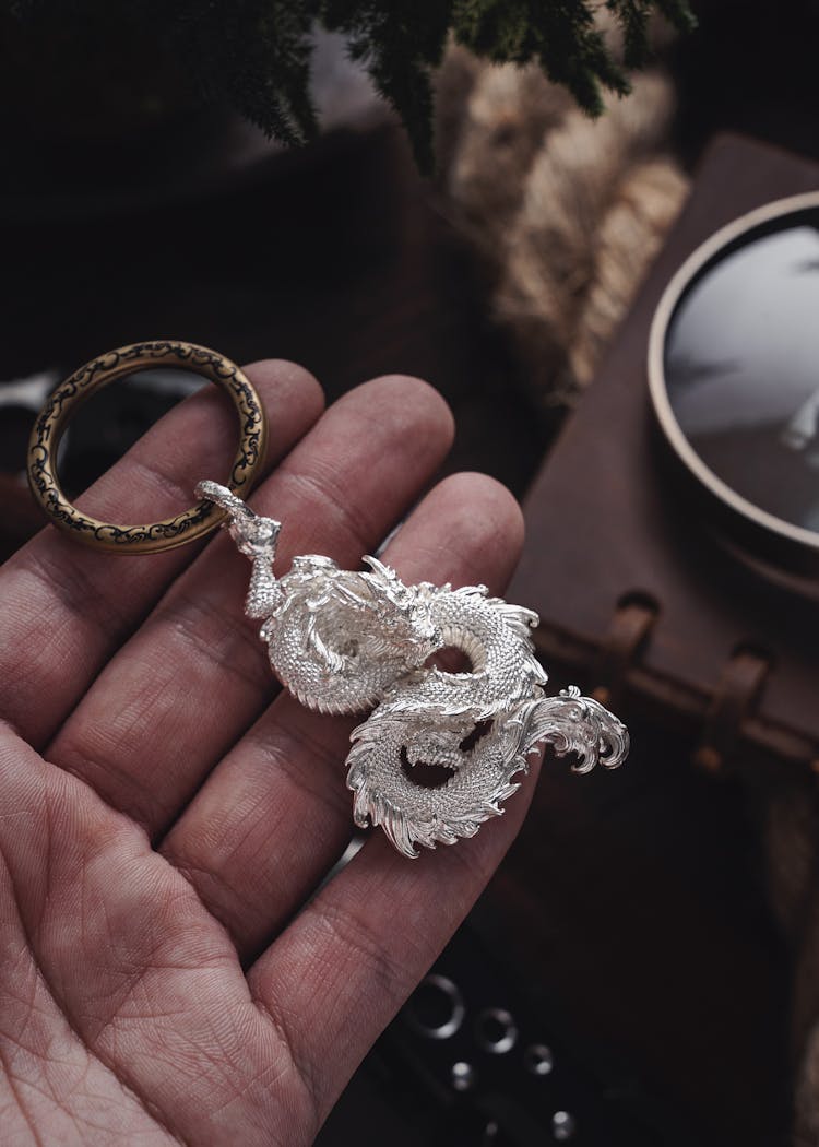 Hand Holding A Vintage Dragon Key Chain 