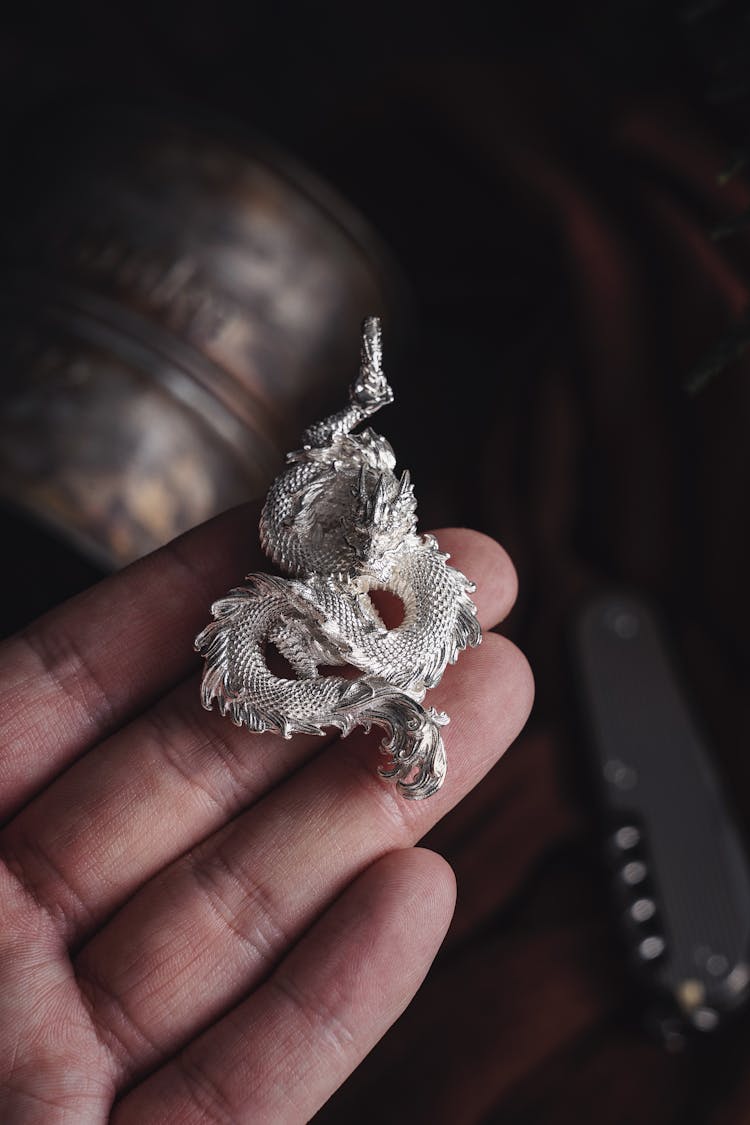 Hand Holding A Silver Vintage Dragon 