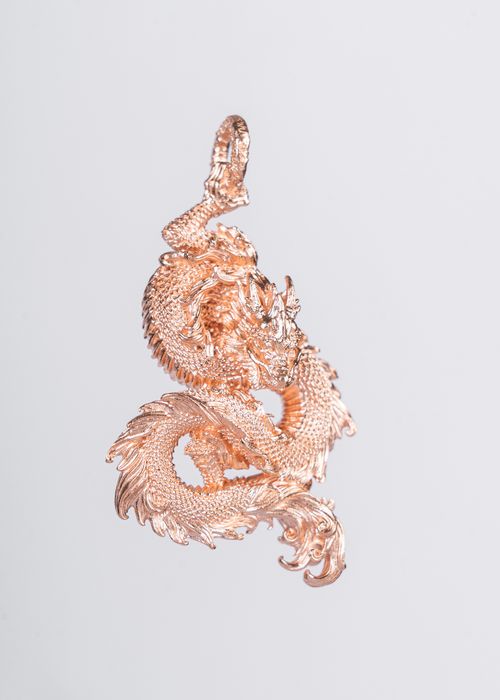 Free A beautifully crafted golden dragon pendant showcasing intricate design and elegance. Stock Photo