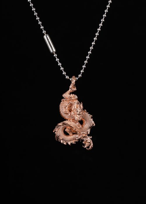 Free A luxurious gold dragon pendant on a chain necklace against a black background. Stock Photo