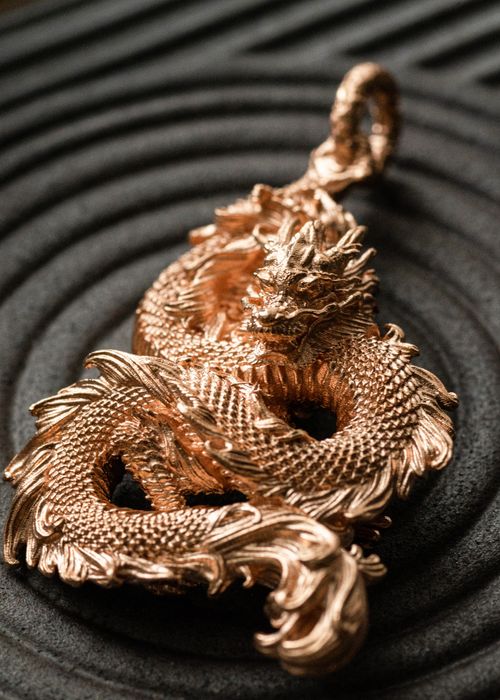 Free Intricately designed golden dragon pendant with artistic elements, perfect for elegant fashion statements. Stock Photo