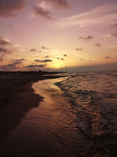 Free Beautiful sunset over the sea with gentle waves on a quiet beach. Stock Photo