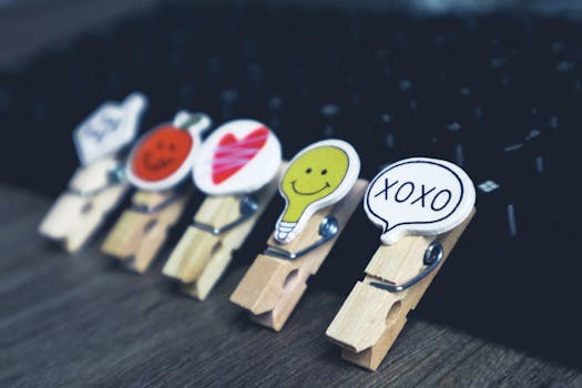Close-up of wooden clothespins with creative emoji designs on a keyboard.