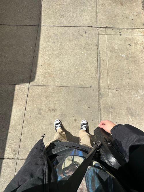 Free Top-down view of person standing on sunlit pavement in casual attire. Stock Photo