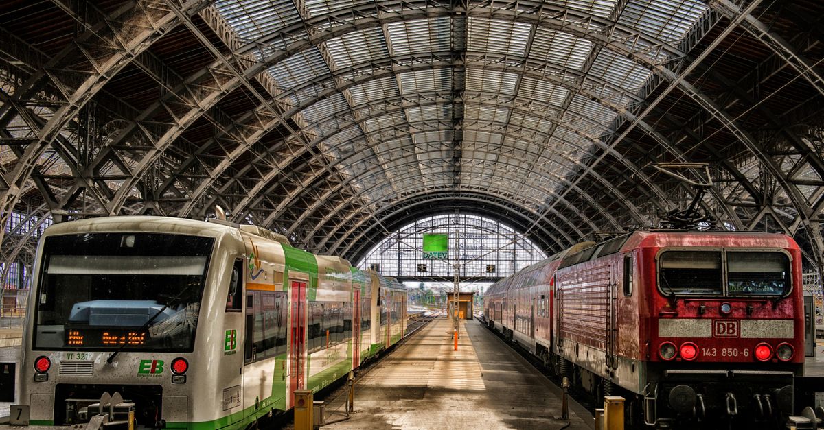 Viajero de Interrail consultando el movil con una eSIM de Europa en un anden de tren