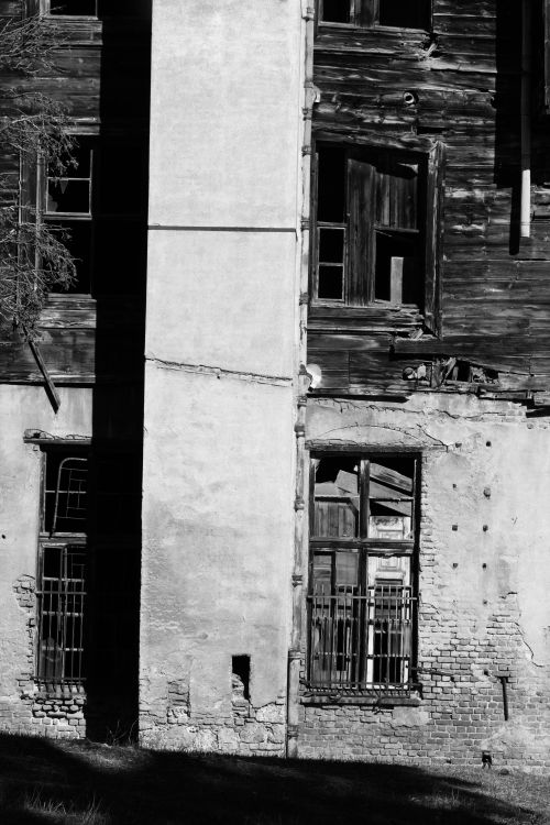 Free A rundown residential building's old facade captured in black and white, conveying a sense of neglect. Stock Photo
