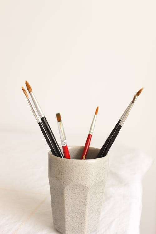 Download premium image of Paintbrushes and art tools in a cup by
